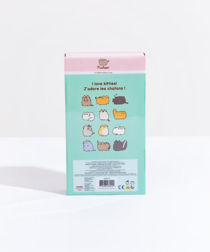 The back of the Pusheen I love Kitties Plush Collectors Set in its original packaging, standing upright in front of a white background. The back features the original comic the plush set is based on, with four rows of three miscellaneous cats, starting with Pusheen holding a pizza and ending with a skunk, which the cats around it react to its smell. The copyright information is noted in small text in a block underneath the comic.