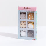 The Pusheen I Love Kitties Plush Collectors Set in it’s original packaging standing upright in front of a white background. The plastic sleeve on top of the set features the Pusheen logo on the top pink banner, the text ‘I love kitties!’ in English and French underneath it. The white bars on the sleeve separate the mini plush into their own square, making the set look like a comic strip. The 8+ age rating is noted on the bottom left, and the GUND manufacturer logo is on the bottom right.