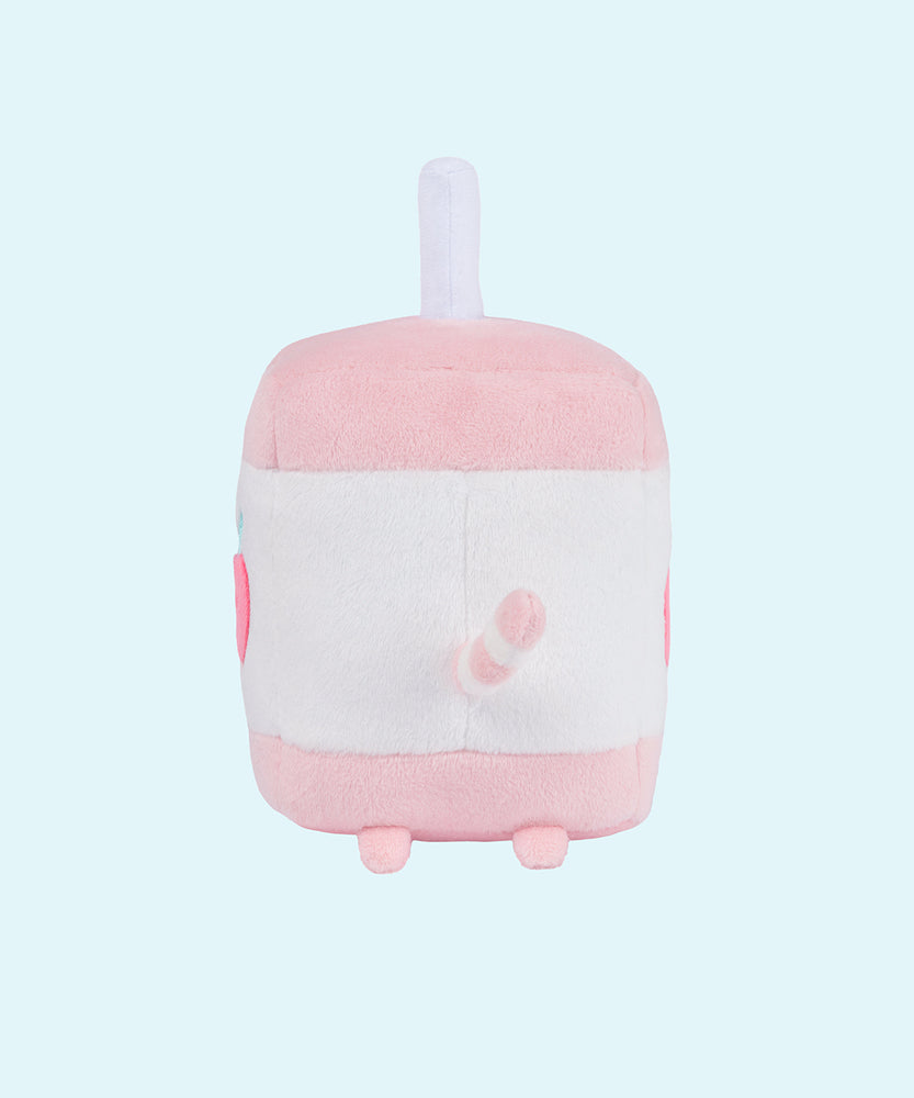 On a light blue background, the Juice Box Sips Plush shows off its white straw detail, plush pink feet, and white and pink striped tail that extends slightly off the body of the plush. 