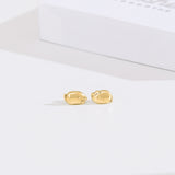 Front view of gold vermeil finish of Lazy Stud Earrings. The earrings are an unmatched pair of Pusheen sitting in two different lounging poses.