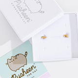 Gold Vermeil finish of Pusheen Lazy Stud Earrings in their white packaging box. The earrings are accompanied by the lid of the packaging box and a mint green informational card about the earrings.