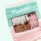 Close-up view of the miniature plush inside the Meowshmallows bag. The white top and bottom edges of the bag have a crinkled look to imitate a bag closure. 
