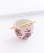 The Pusheen Ramen Bowl with the chopsticks resting in the holes of the bowl, in front of a white background.