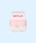The back view of the Juice Box Sips Plush shows off pink ‘Milk’ embroidery, pink feet, and white and pink striped tail that extends slightly off the body of the carton-shaped plush. 