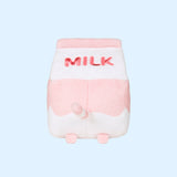 The back view of the Juice Box Sips Plush shows off pink ‘Milk’ embroidery, pink feet, and white and pink striped tail that extends slightly off the body of the carton-shaped plush. 