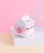 The back view of the Juice Box Sips Plush shows off pink ‘Milk’ embroidery, pink feet, and white and pink striped tail that extends slightly off the body of the carton-shaped plush. 