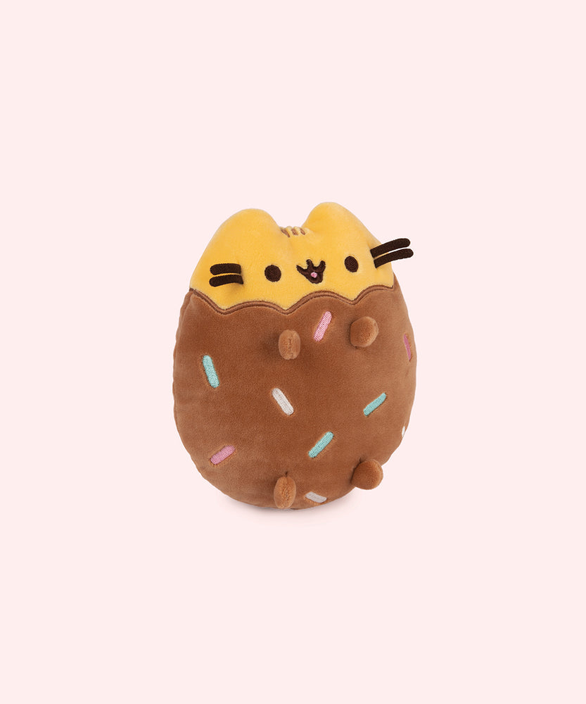 Right quarter view of Chocolate Dipped Cookie Squisheen. In the brown lower portion of the plush there is a scalloped edge that meets the yellow portion of Pusheen’s head and ears. 