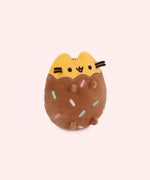 Right quarter view of Chocolate Dipped Cookie Squisheen. In the brown lower portion of the plush there is a scalloped edge that meets the yellow portion of Pusheen’s head and ears. 