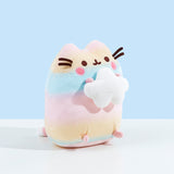 A quarter profile of the Rainbow Pusheen plush facing the right. She almost looks like a little Easter egg. Pusheen's paws are a light pastel pink. The pink in Pusheen's blush is a much more saturated pink.