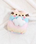 Back view of the Rainbow Pusheen Plush in front of a light blue background. Pusheen's two back stripes are white and embroidered into the plush. Pusheen's tail is a light pastel pink with white stripes. The plush is in front of a light blue background.