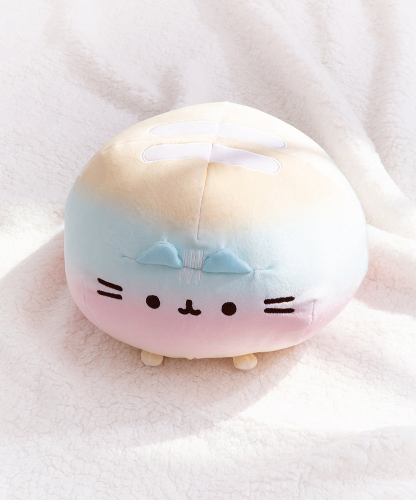Top view of the round Rainbow ombre squisheen. The yellow top of the plush has two white embroidered stripes.  