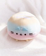Top view of the round Rainbow ombre squisheen. The yellow top of the plush has two white embroidered stripes.  