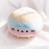 Top view of the round Rainbow ombre squisheen. The yellow top of the plush has two white embroidered stripes.  