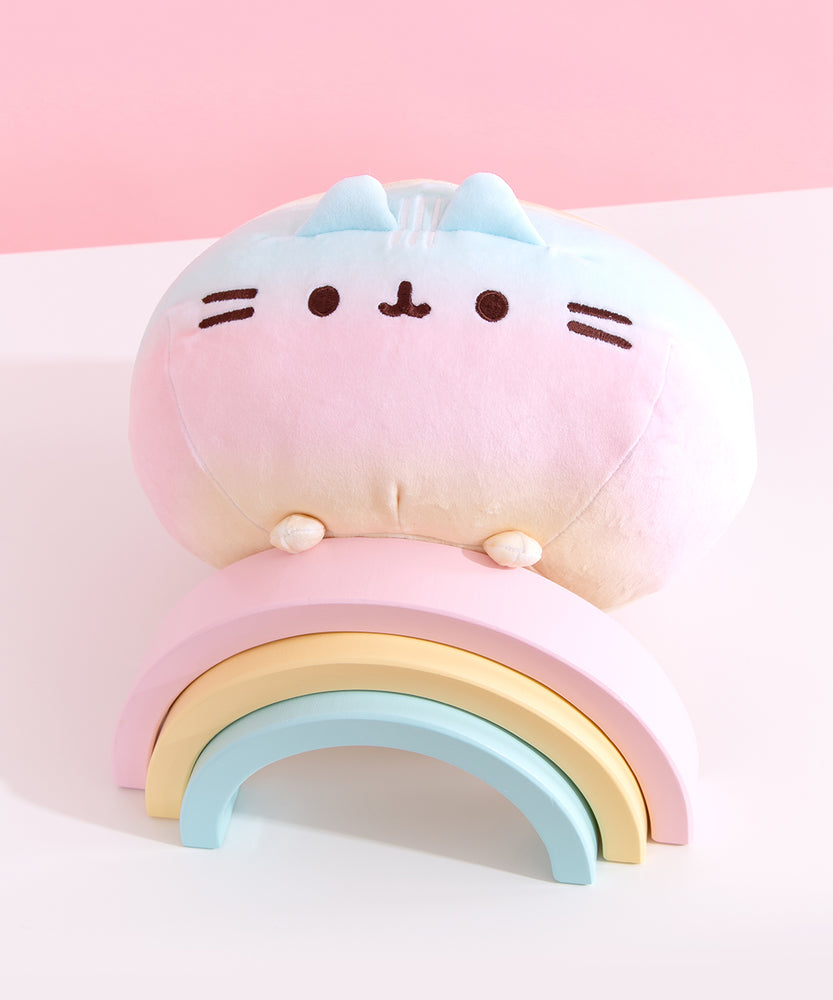 Top view of the round Rainbow ombre squisheen. The yellow top of the plush has two white embroidered stripes.  
