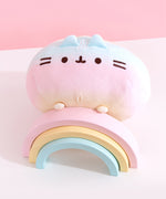 Top view of the round Rainbow ombre squisheen. The yellow top of the plush has two white embroidered stripes.  
