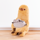 A quarter profile view of the Pusheen and Sloth Set facing the left, sitting directly on the wooden floor in front of a white background. It’s clear from this angle that Sloth sits directly on his base, and his legs point straight out. 