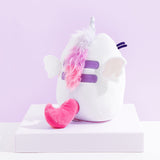 Back view of the Super Pusheenicorn Plush on top of a white square pedestal, in front of a light purple background.